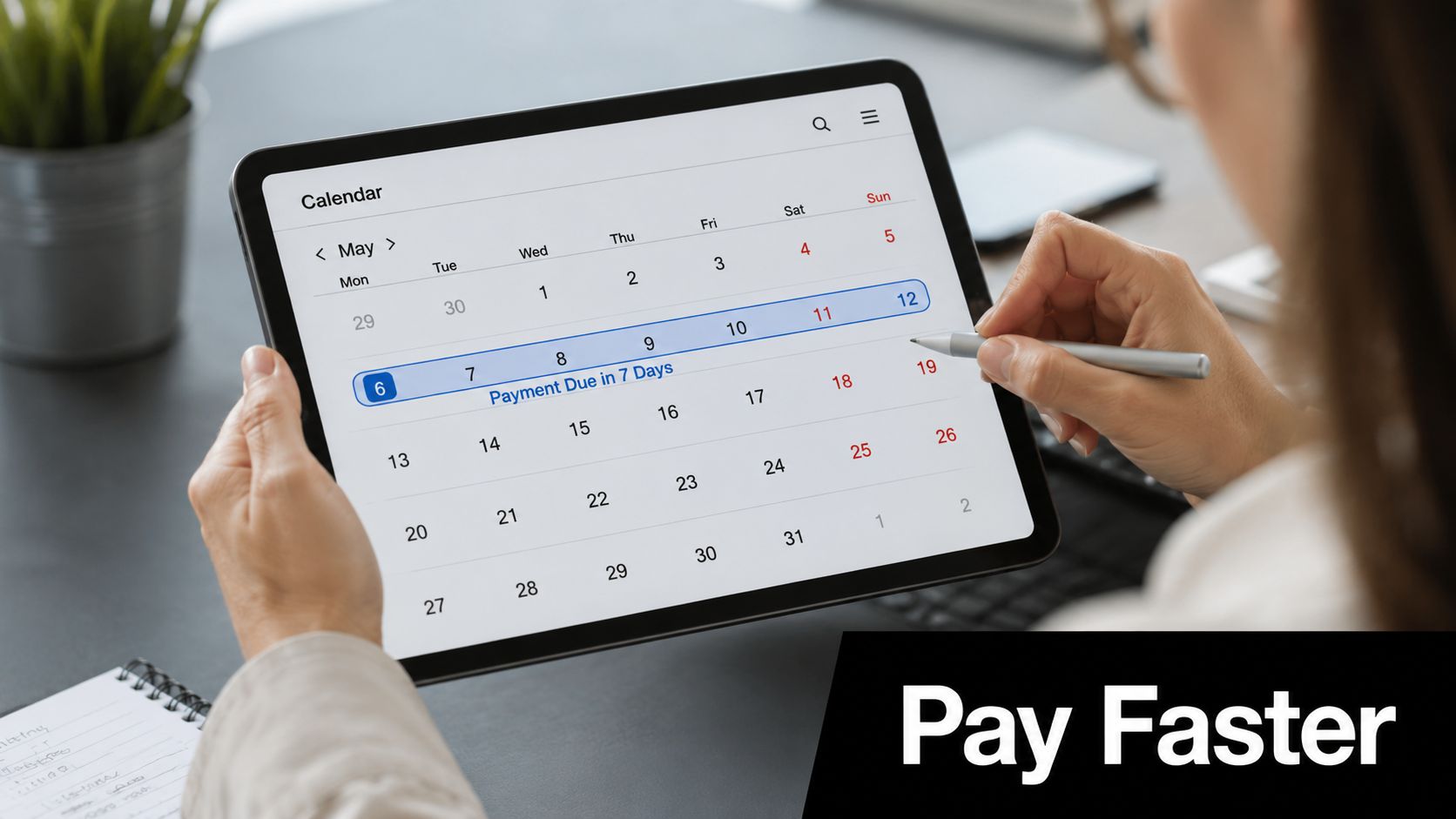 A person using a stylus on a tablet showing a calendar with a payment due notification.