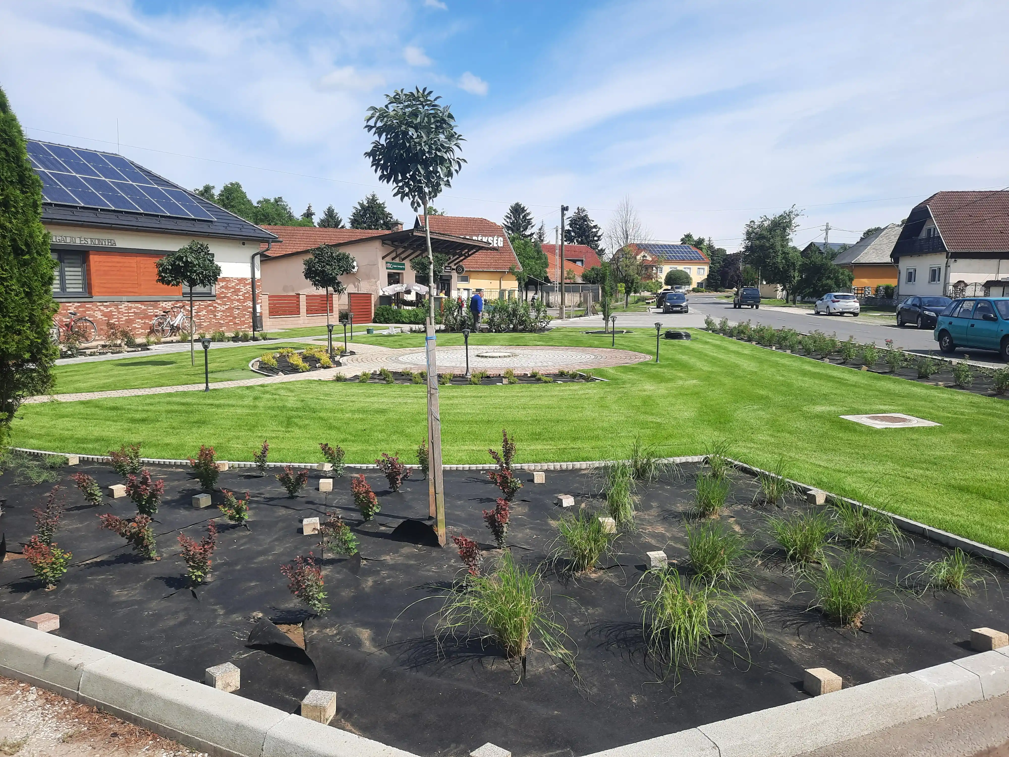 Modern köztéri park kavicságyakkal és kövezett sétánnyal