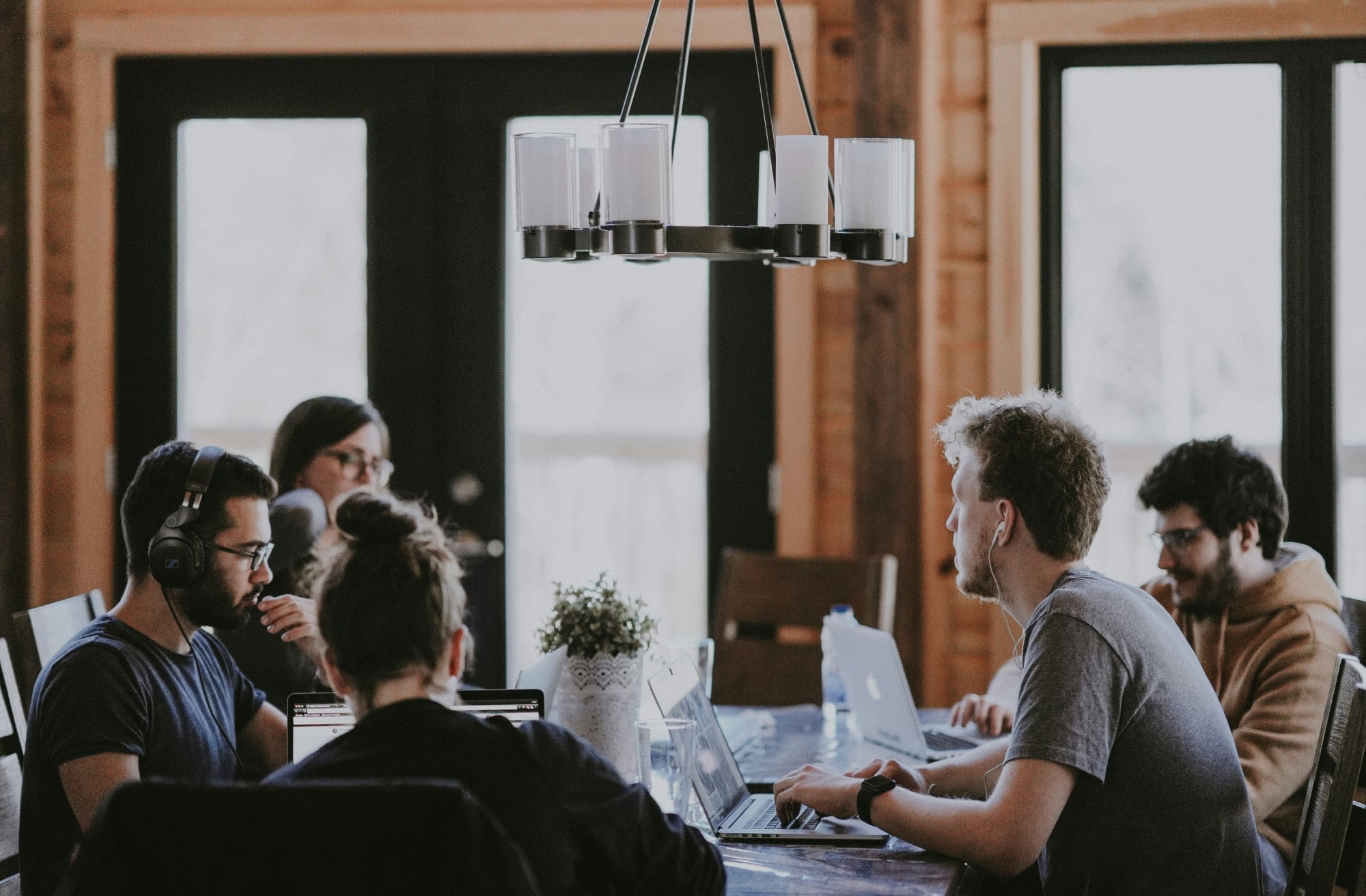 A group of people around the table with their laptops.