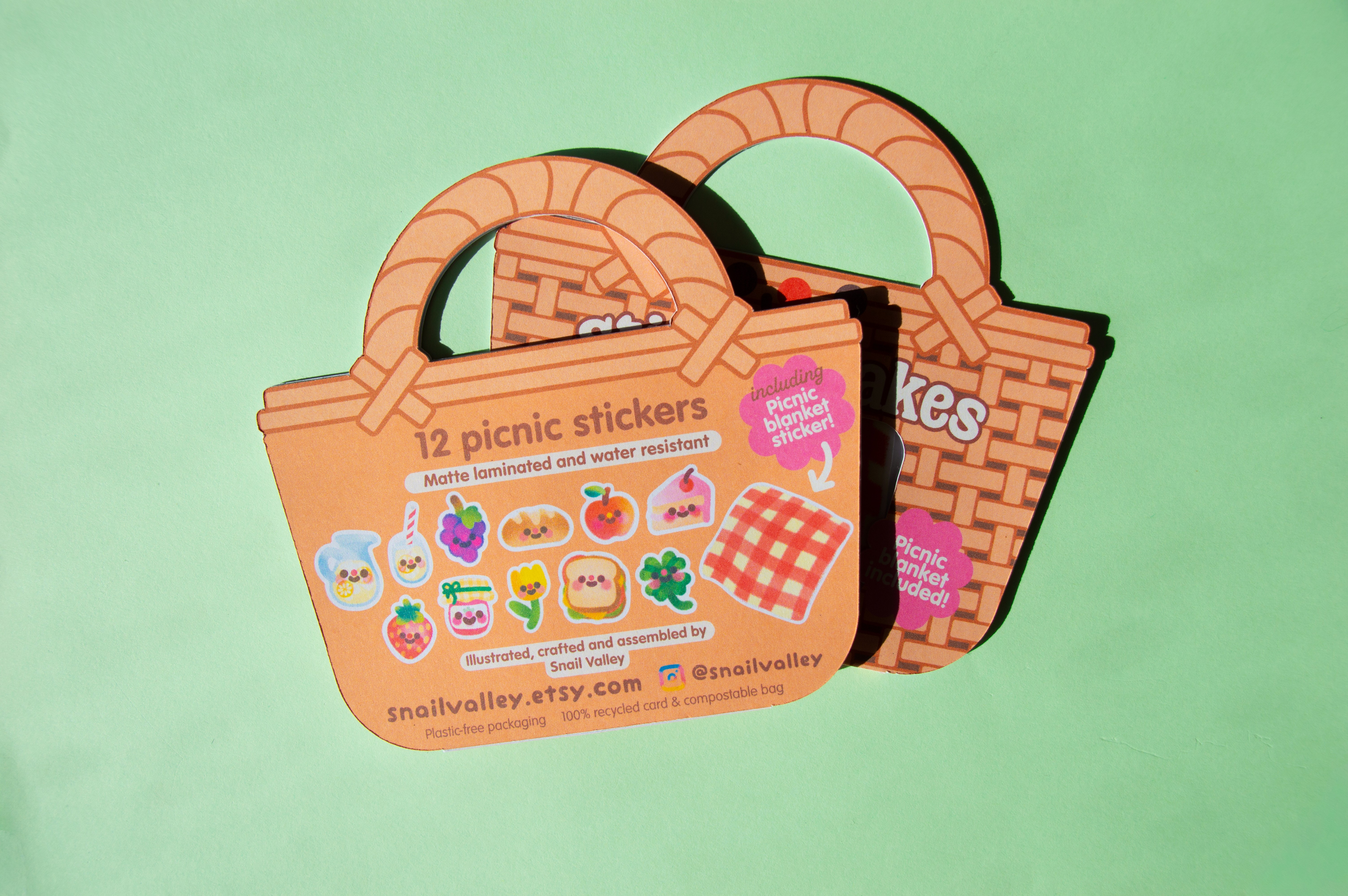 The back of the packaging reads: "12 Picnic stickers. Matte Laminated and water resistant. Illustrated, crafted and assembled by snail valley". It also pictures all of the stickers included inside.