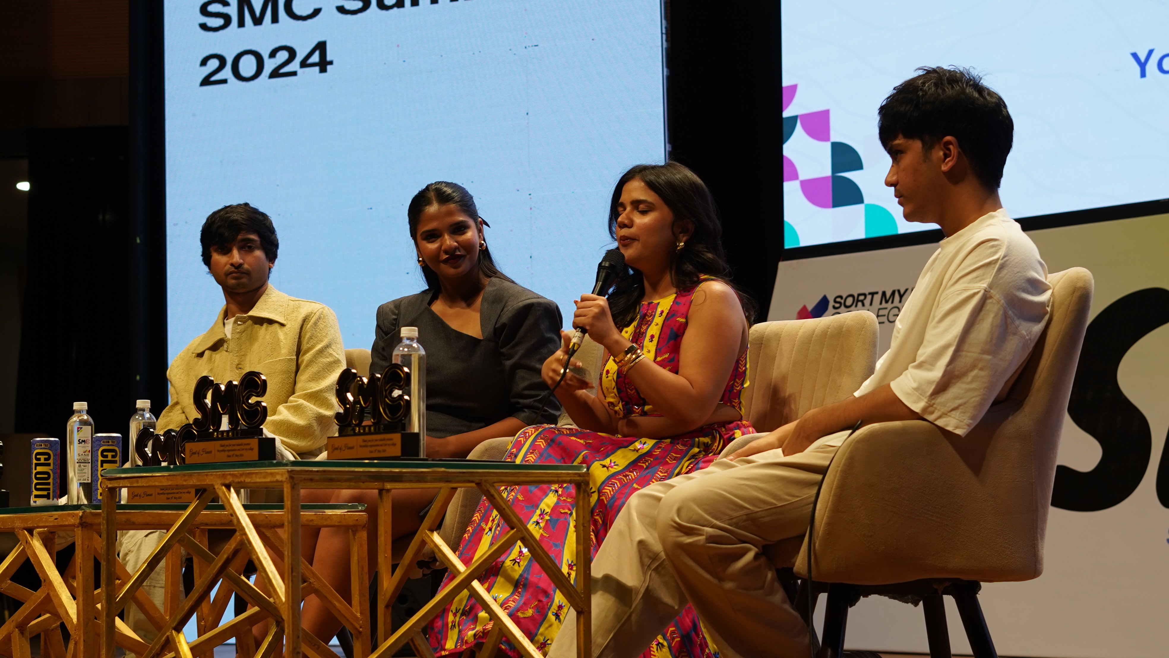 person discussing while standing in front of a large screen in front of people inside dim-lighted room