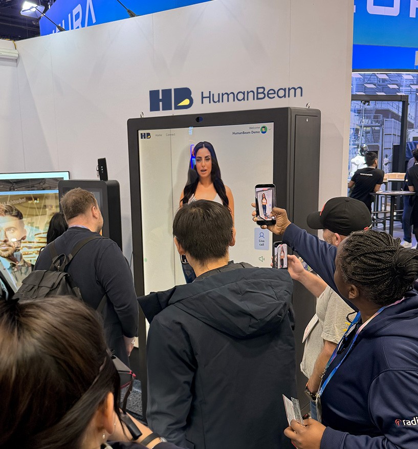 Holographic AI presenter at an exhibitor booth attracting attendees and delivering an interactive product demonstration