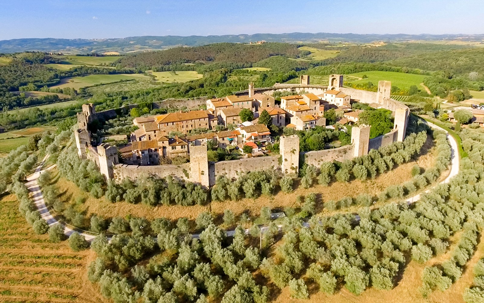 Aerial view of Monteriggioni's medieval walls and surrounding Tuscan landscape.
