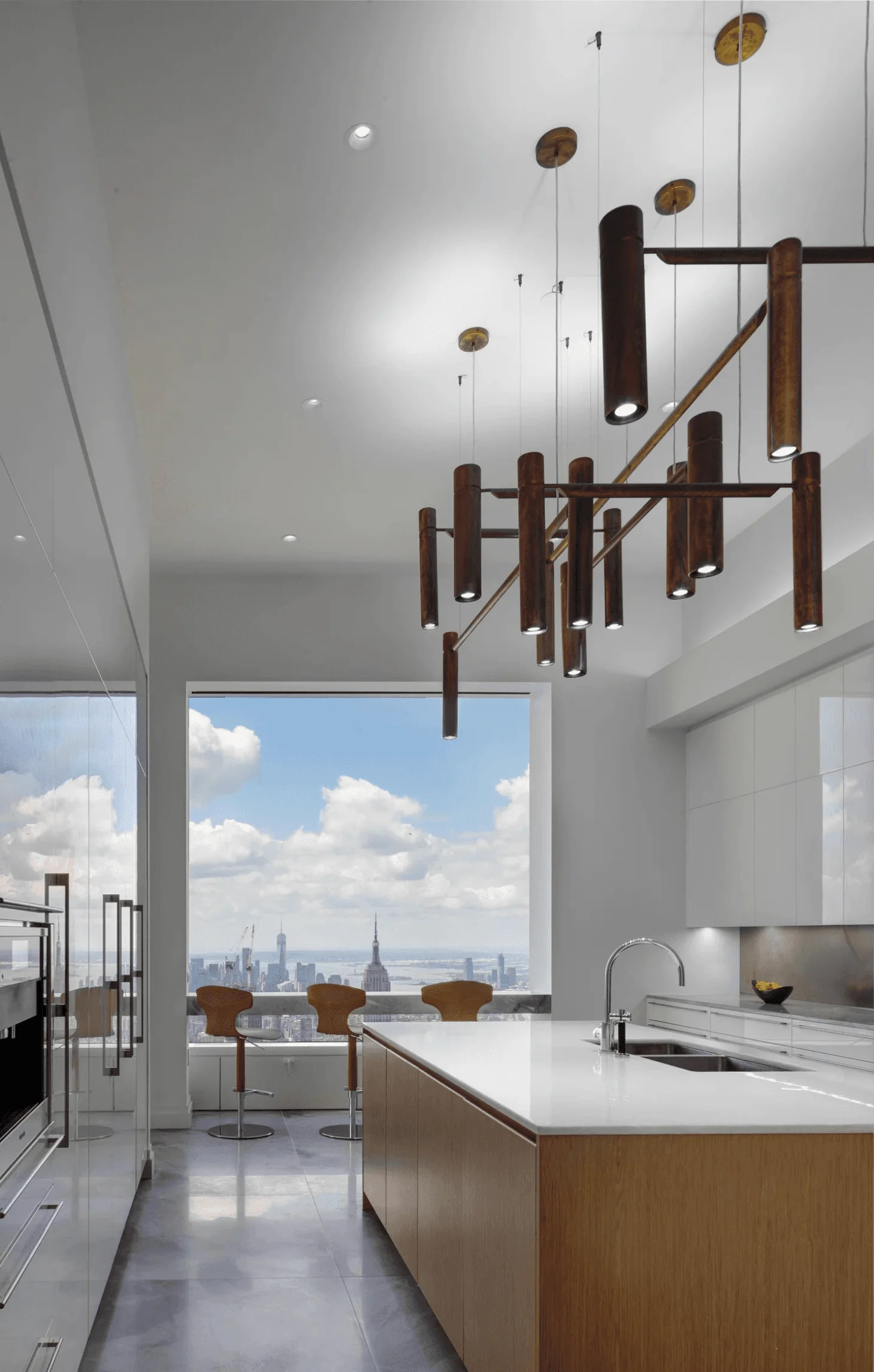 High-end appliances and a contemporary chandelier furnish this spacious white kitchen