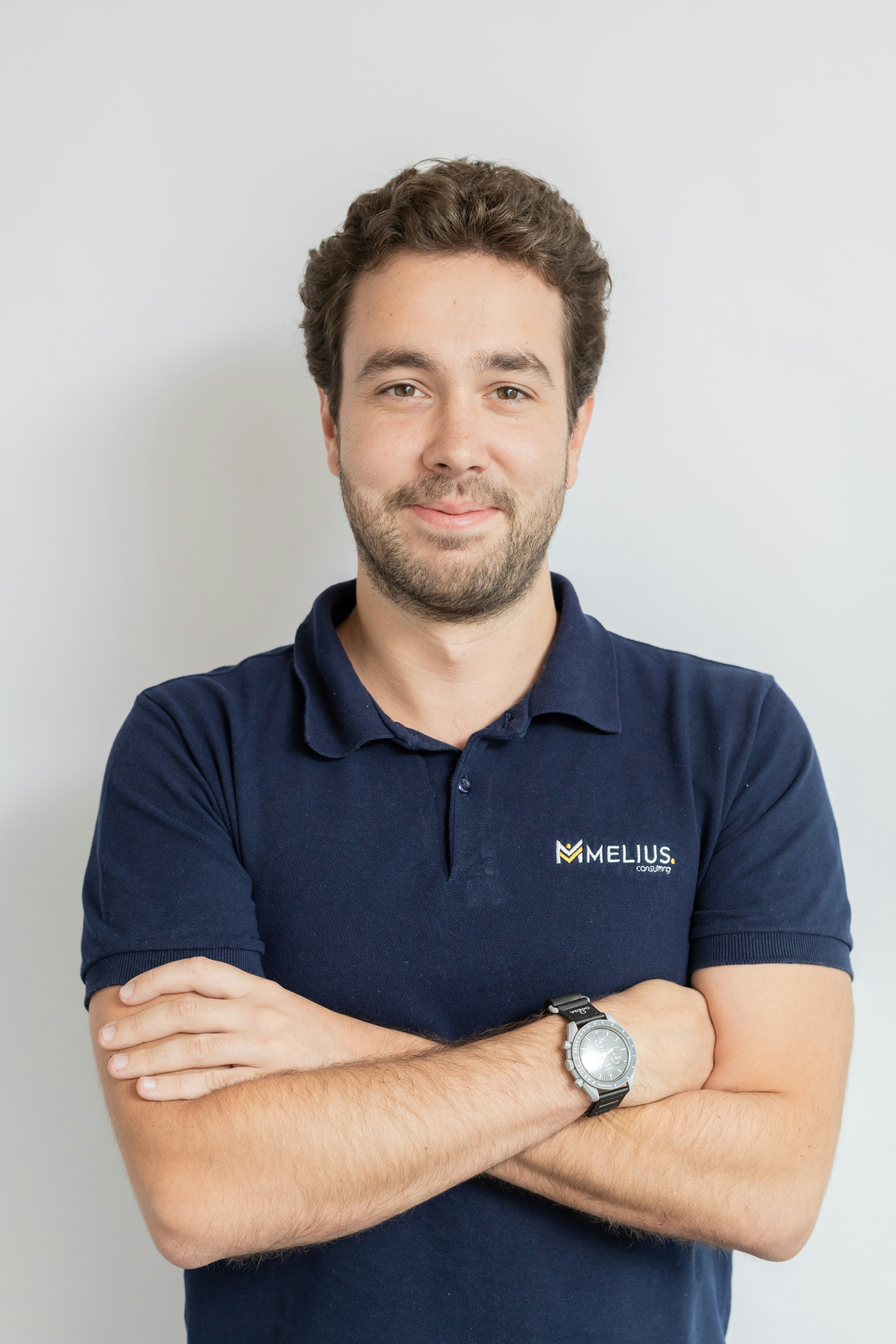 Man wearing a dark blue polo shirt with arms crossed