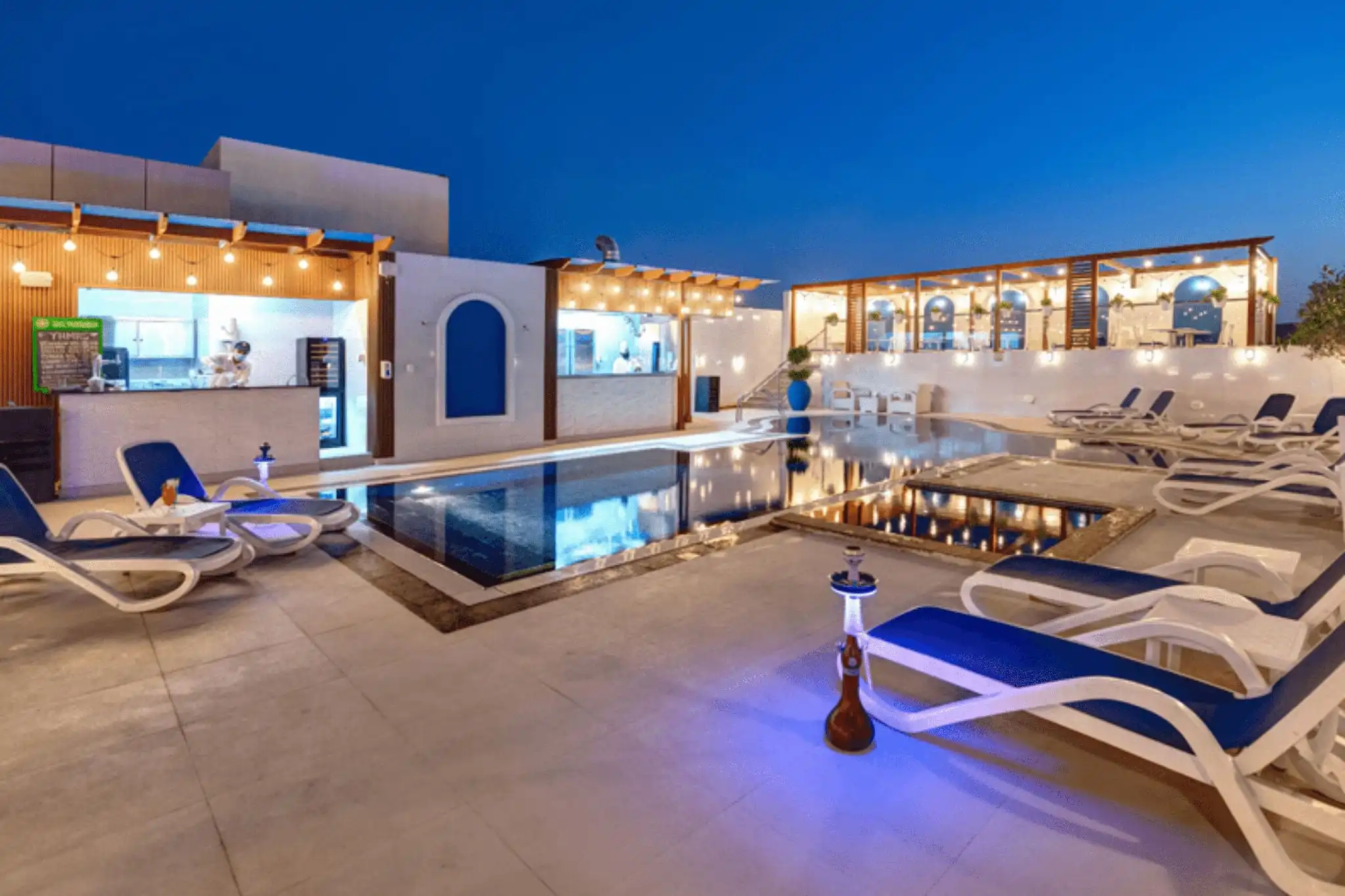 The outdoor pool at Donatello Hotel, a pet-friendly hotel in Dubai's Al Barsha district, with loungers and an open-air bar