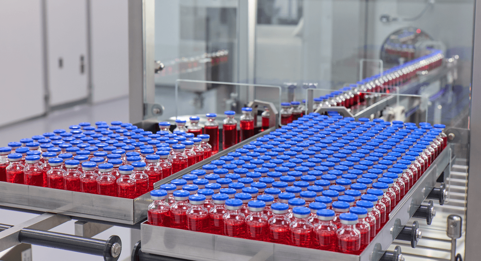 Vials of red liquid on conveyor - 503a vs 503b