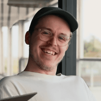 A thoughtful young person with dark hair gazes to the side, captured in soft black and white lighting.