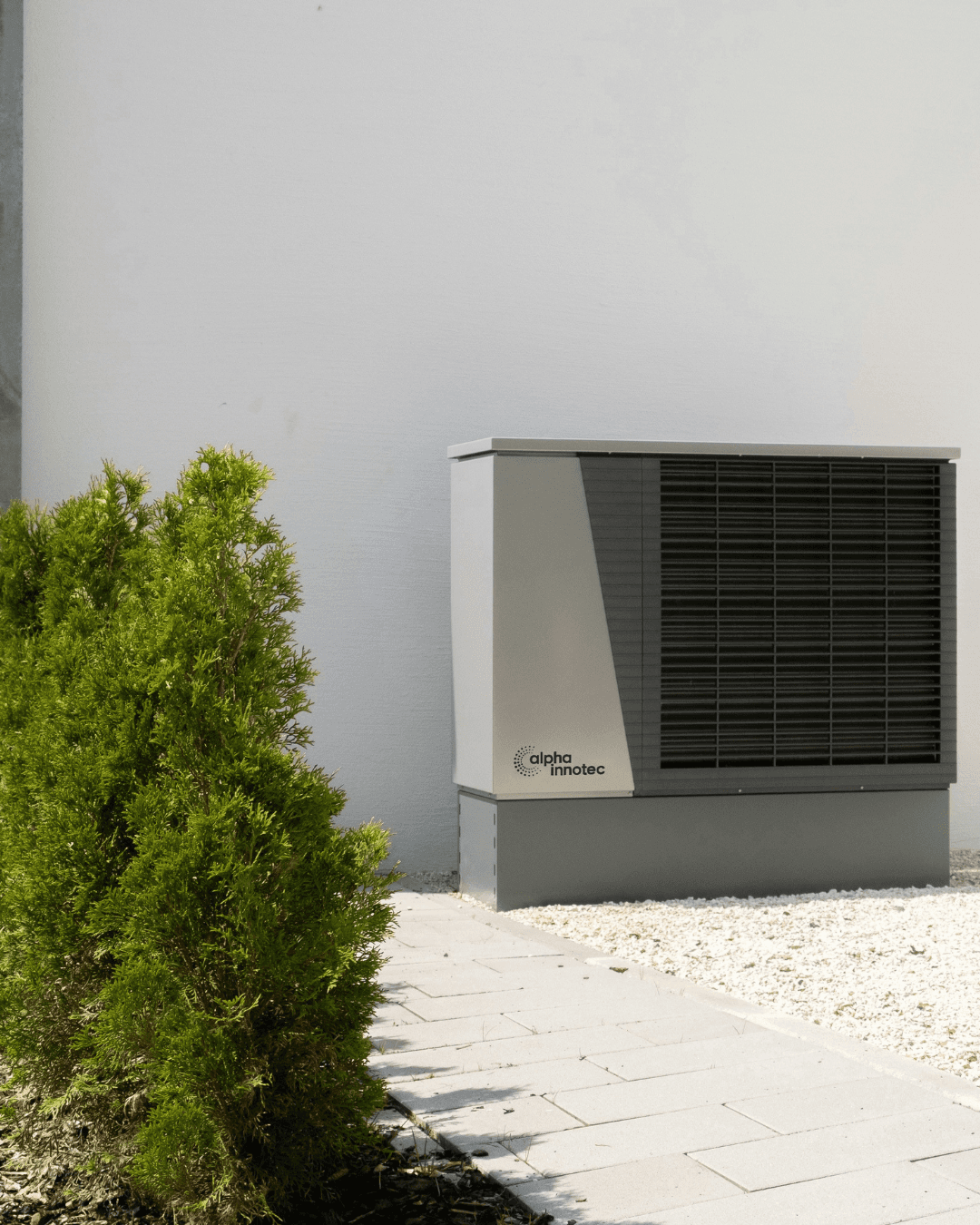 Moderne alpha innotec Wärmepumpe vor einem Haus