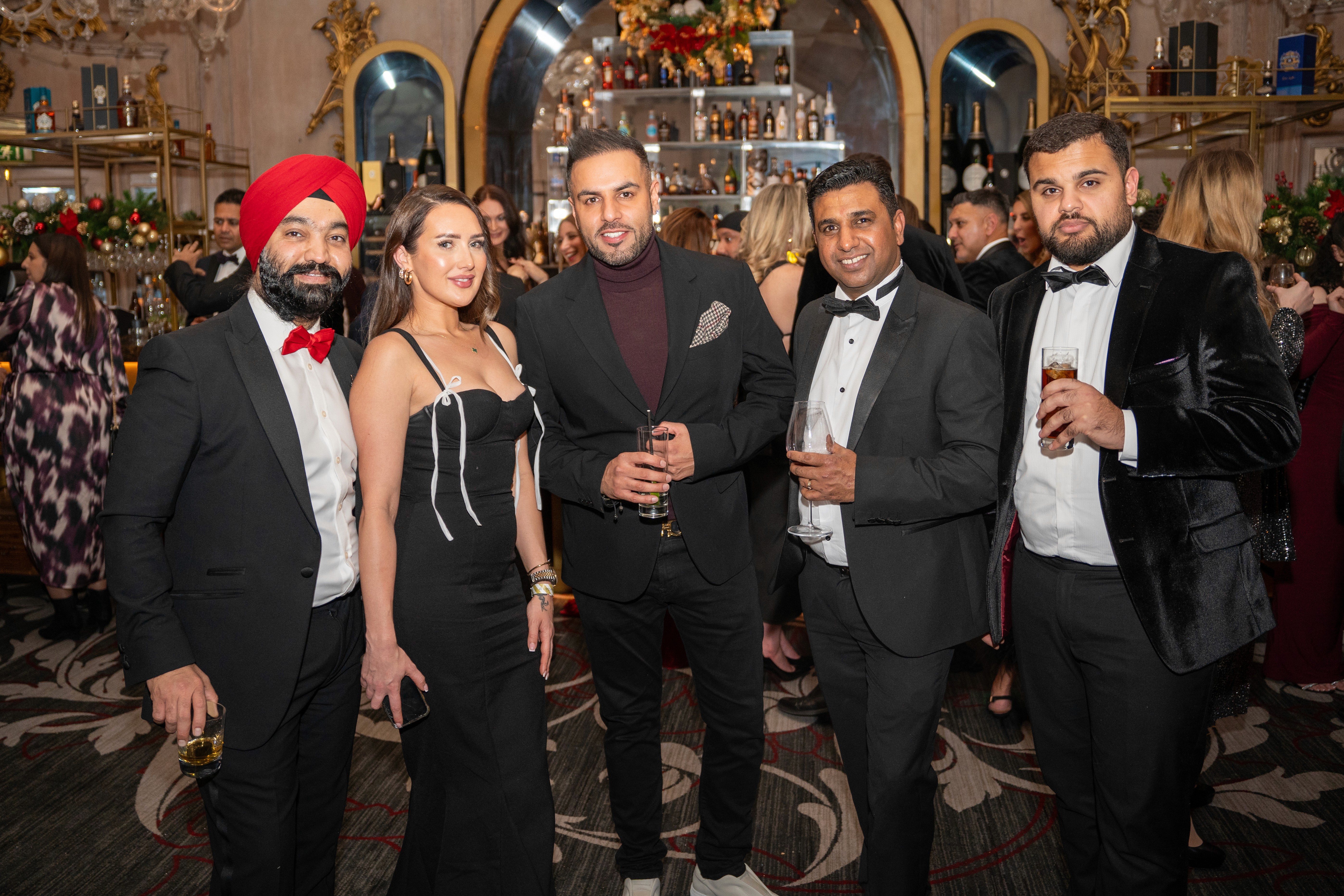 Guests dressed in black tie attire posing together at a National Property Club event held at the Gotham Hotel in Manchester, captured by Seven Media during the evening celebration.