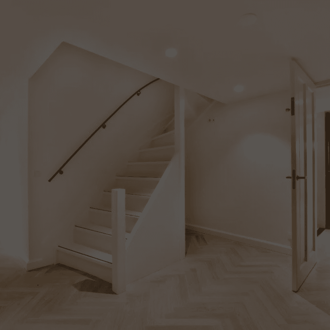 Modern staircase with white steps and minimal black handrail in a clean, well-lit interior space with herringbone wood flooring