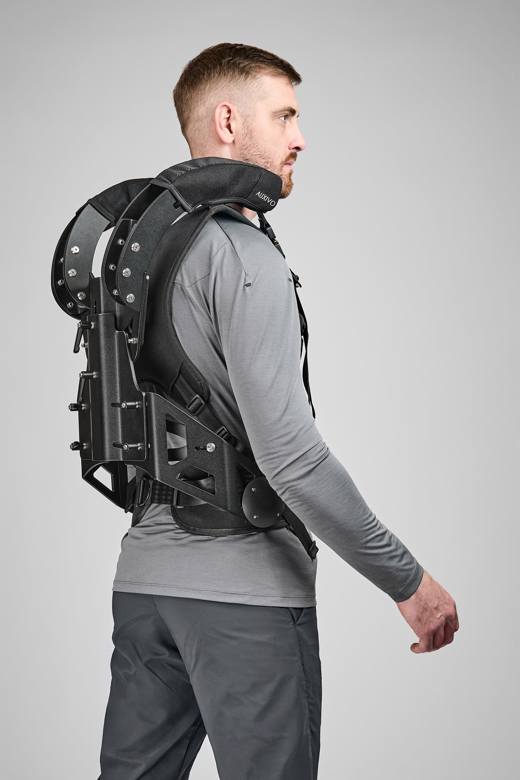 Auxivo CarrySuit exoskeleton seen from the back worn by a user.