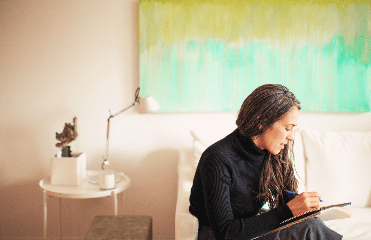 woman sitting while working on laptop and smiling 