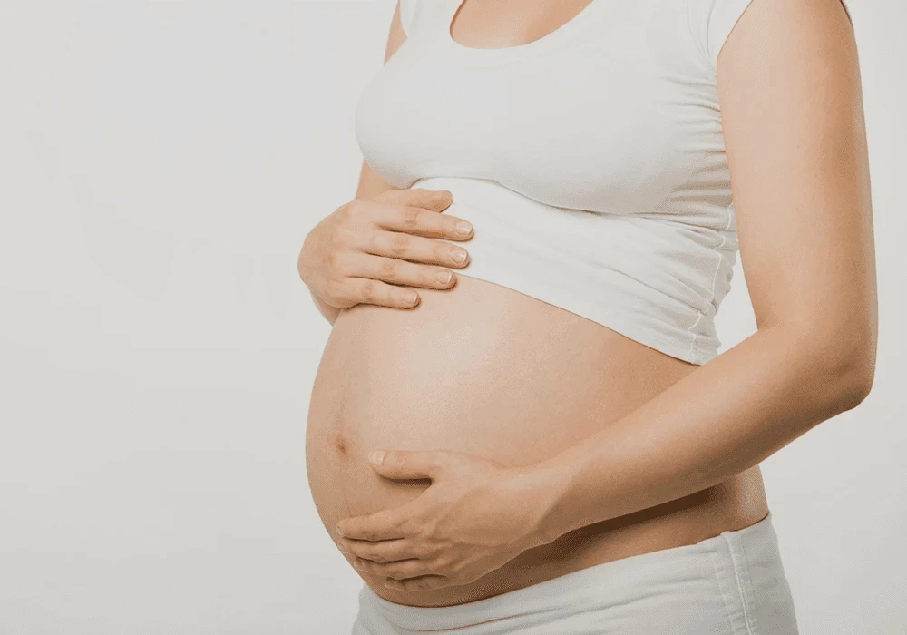 Pregnant woman cradling her baby bump