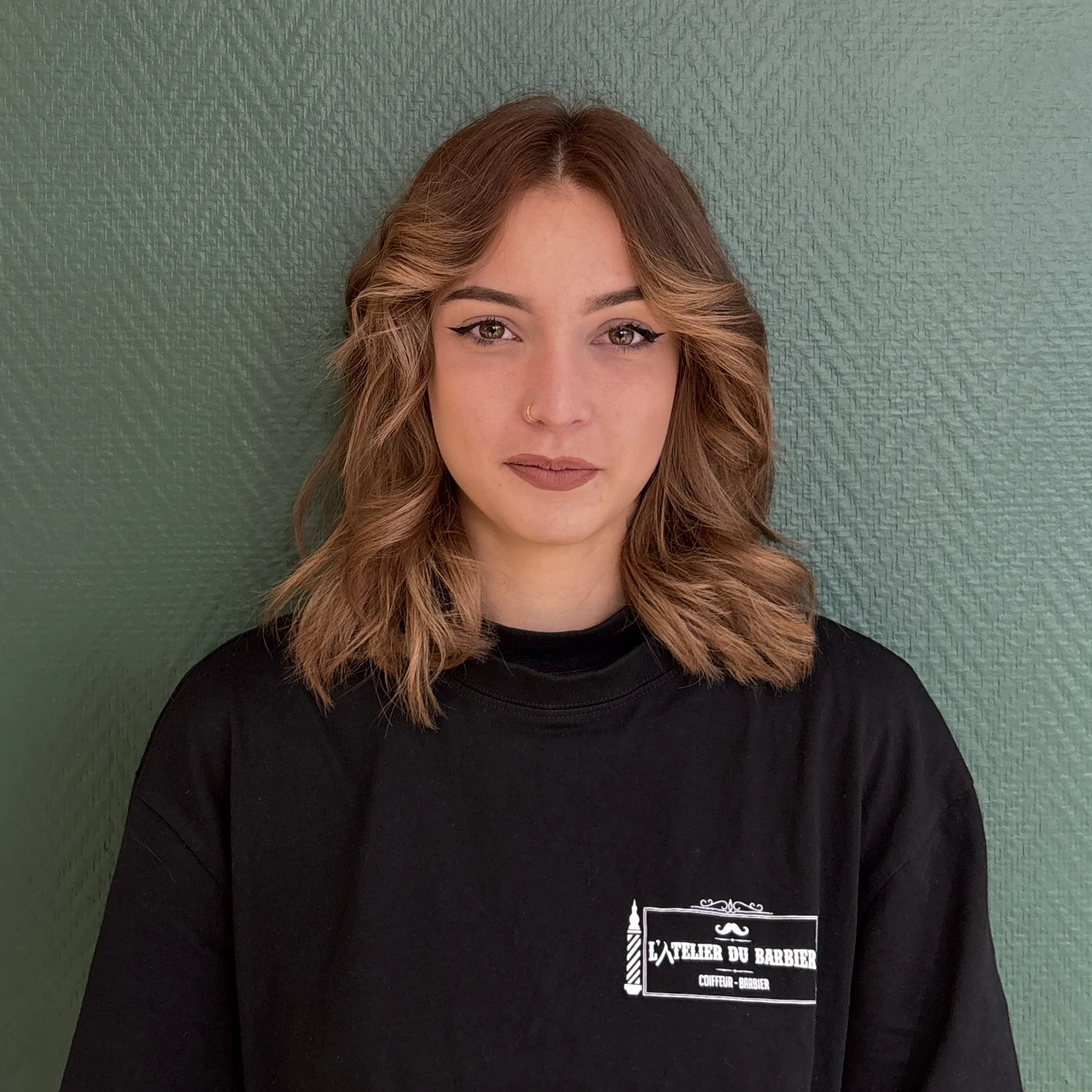 Three young people walk through a dry grassy field.