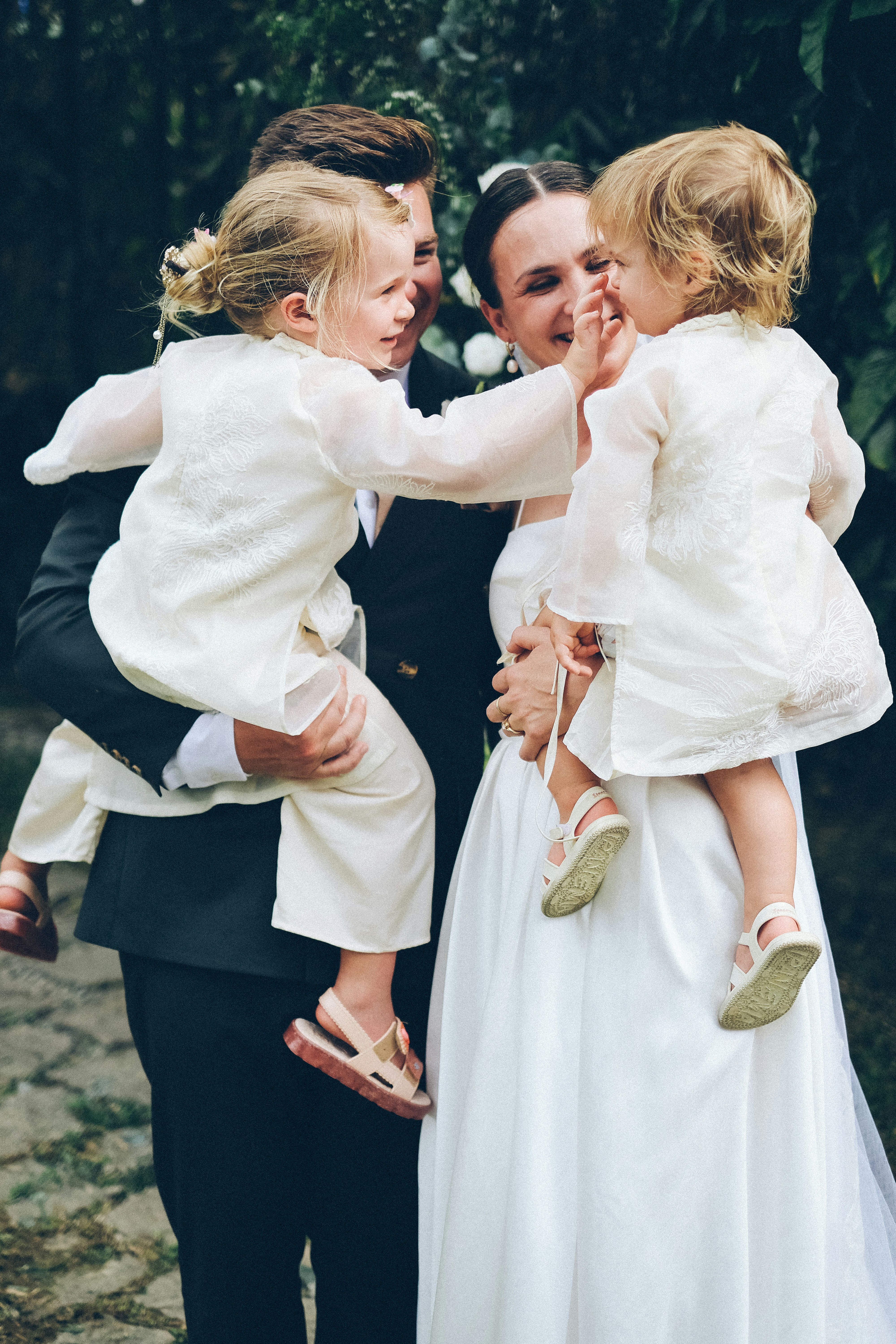 deux-enfants dans les bras des mariés le jour de la cérémonie