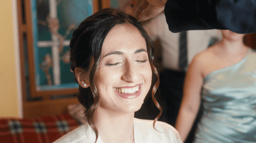 A woman with red hair wears a lavender coat and a white sweater, accessorized with a gray scarf. She has a calm expression against a neutral background.