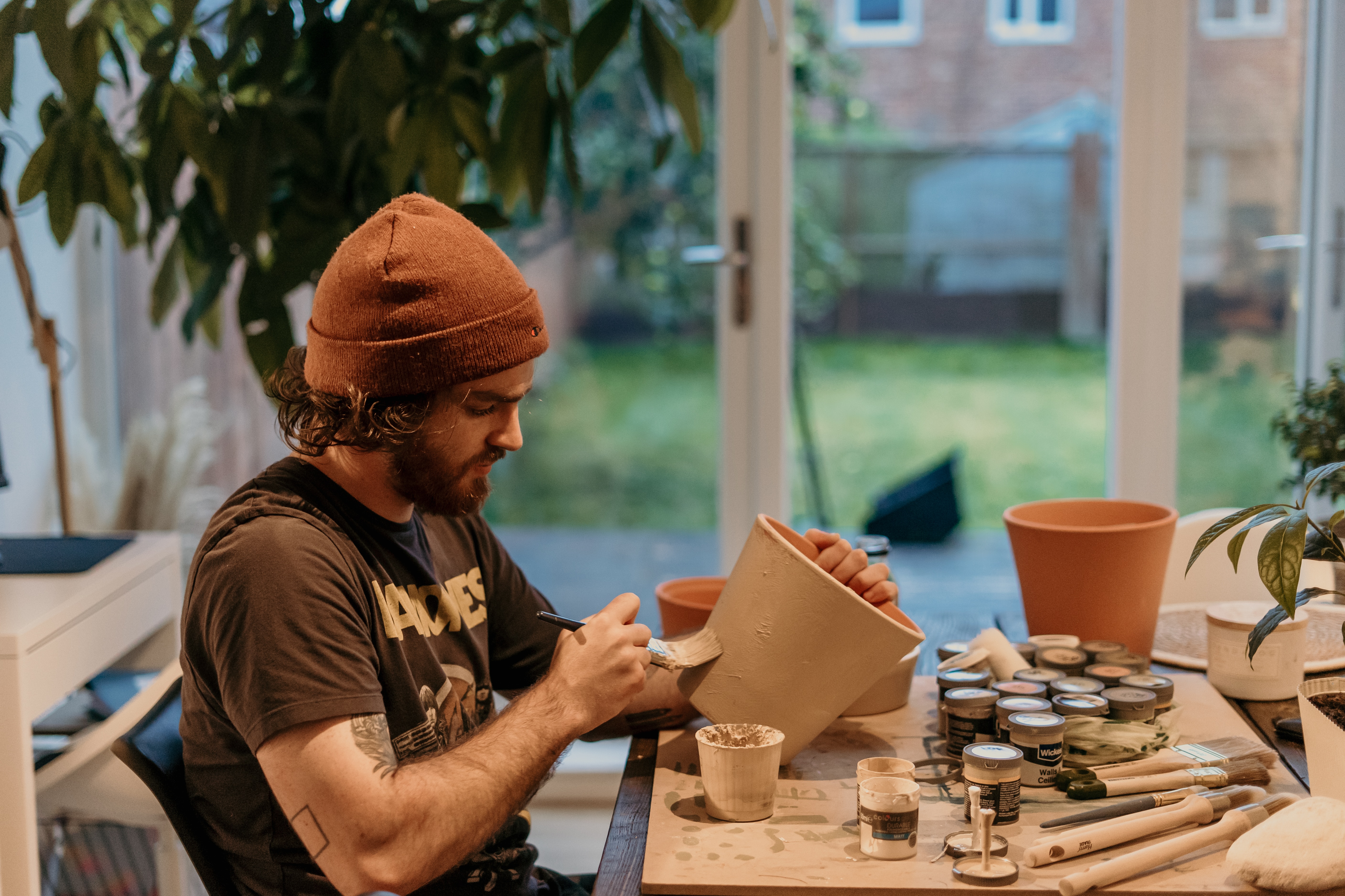 Man glazing pot in the studio