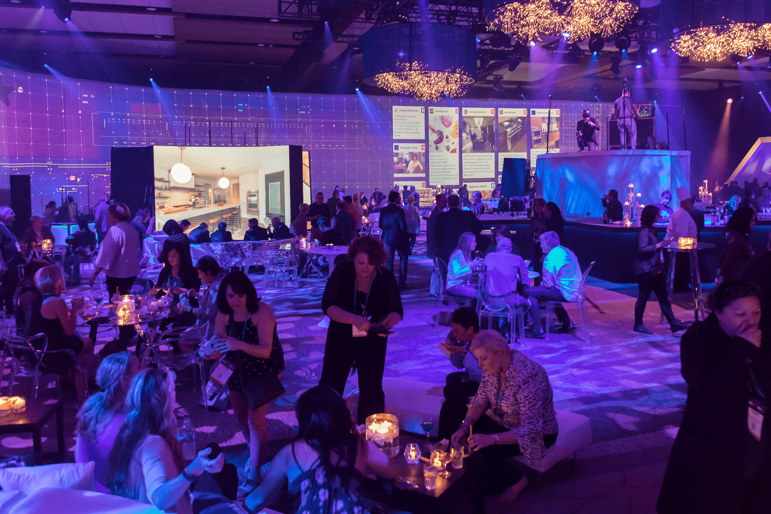 Thermador attendees inside demo ballroom with candles, moodlighting and staging