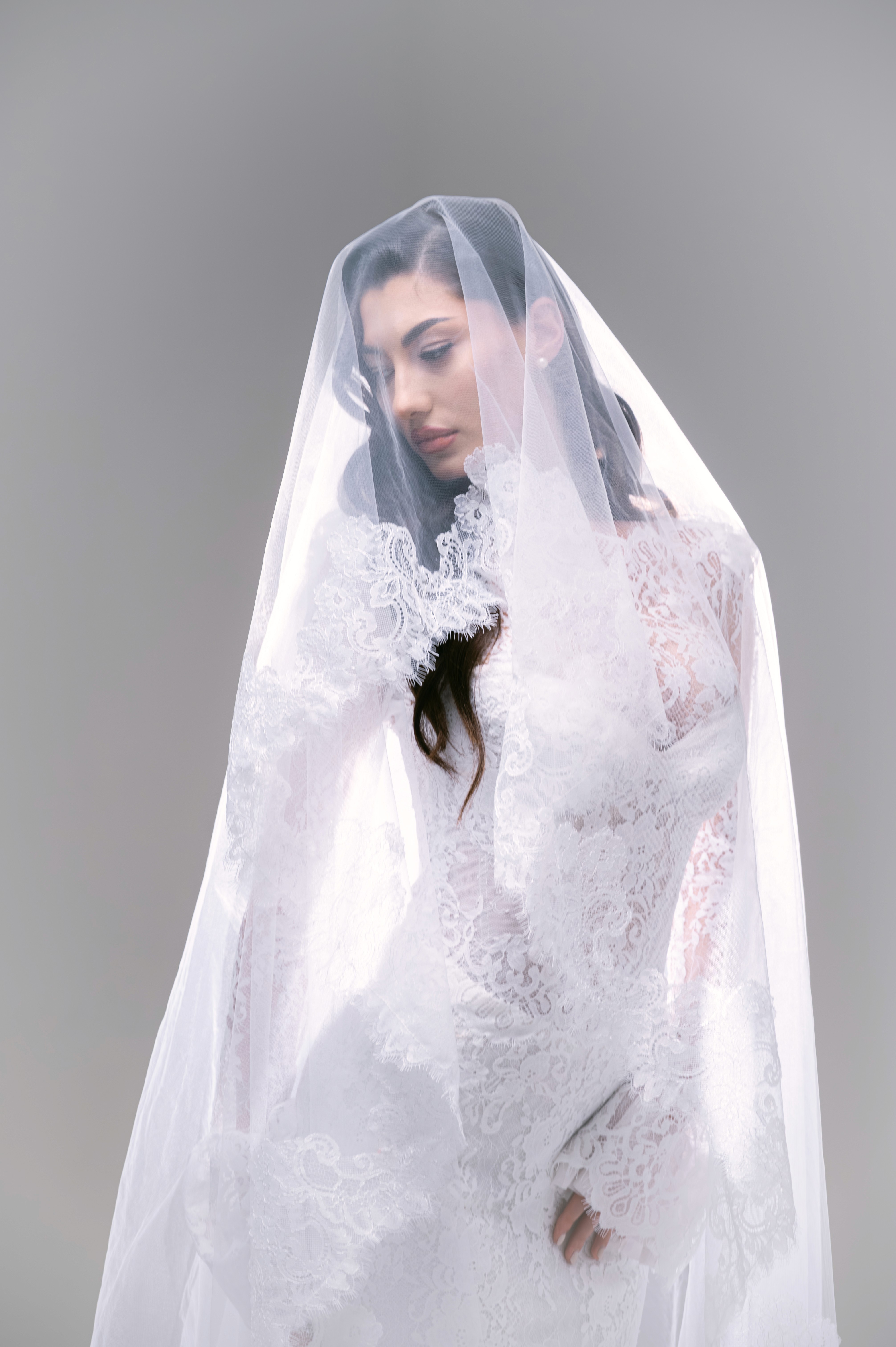 Mireasă fotografiată cu voal și lumină soft într-un decor minimalist, fotografie bridal în București