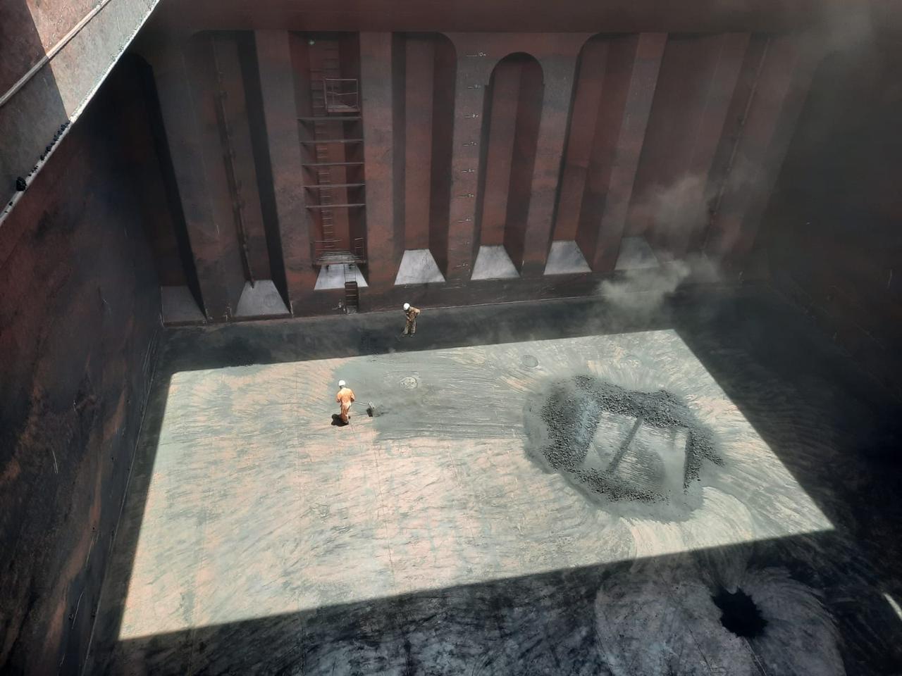 an overview of a cargo hold being swept by the shore gang and getting ready toi be cleaned