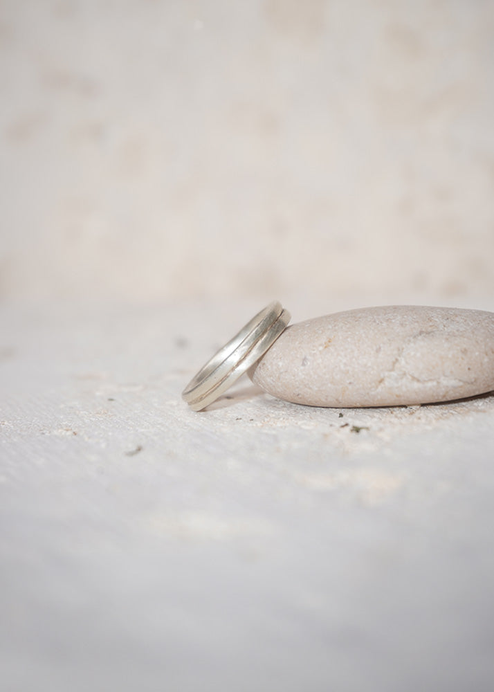Silver ring on a light stone surface