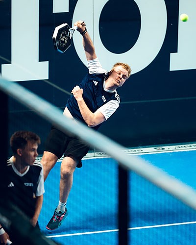 Antti Kampman padel-kentällä lyömässä kick-smashia