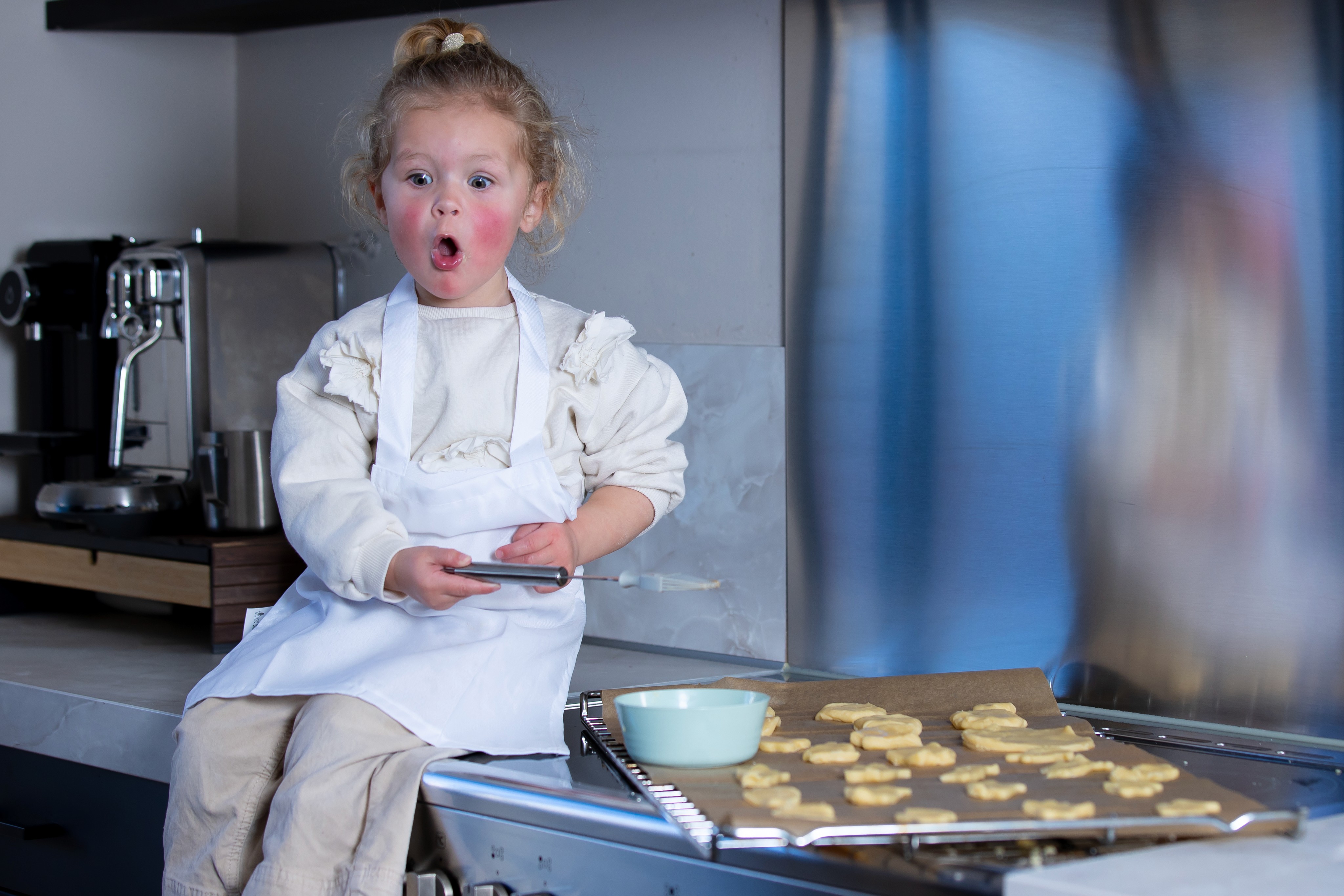 Kindje op aanrecht met koekjes