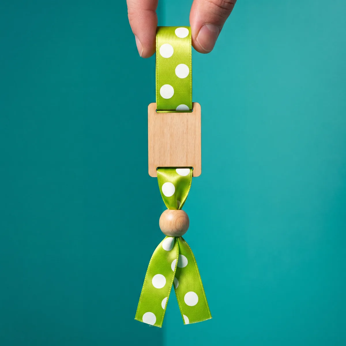 Close-up of the wooden plate and adjustment bead on a fabric wristband