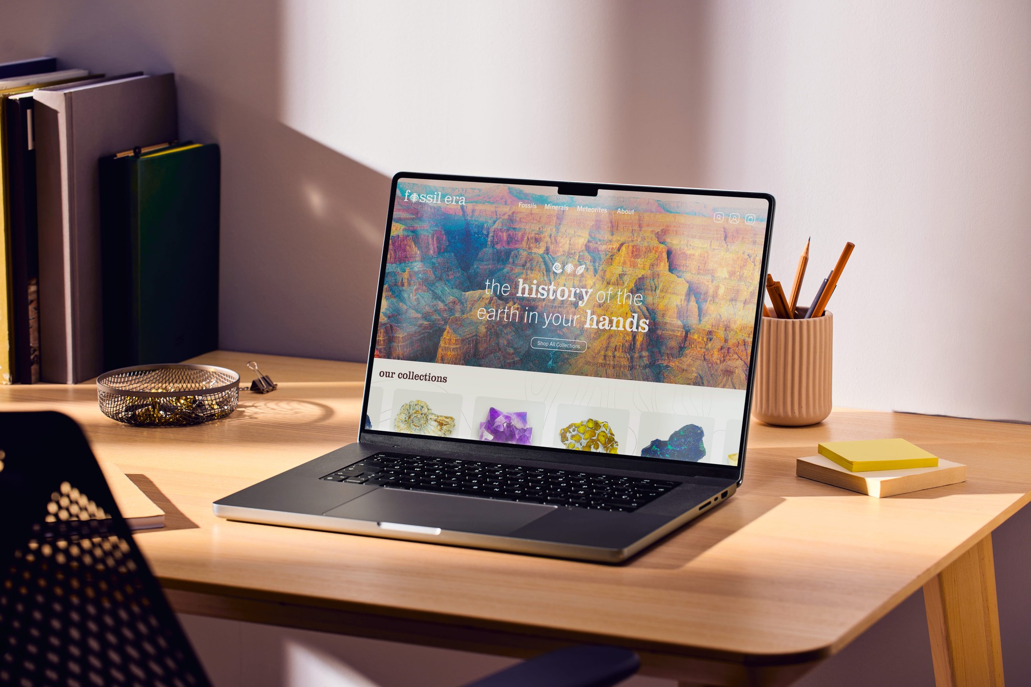 Laptop siting on a desk with the homepage for Fossil Era.