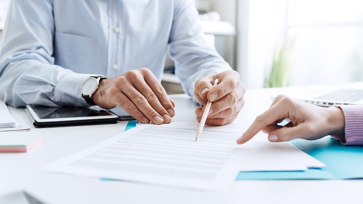 Close shot of a person with a pencil marking a document