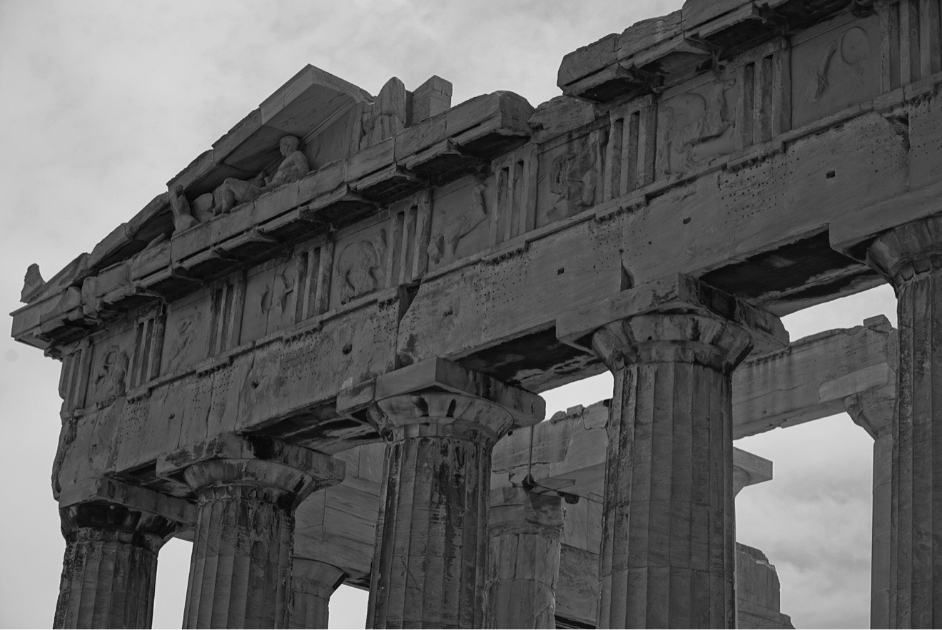 Black and white detail of the Parthenon's carved stone frieze and columns in Athens, Greece
