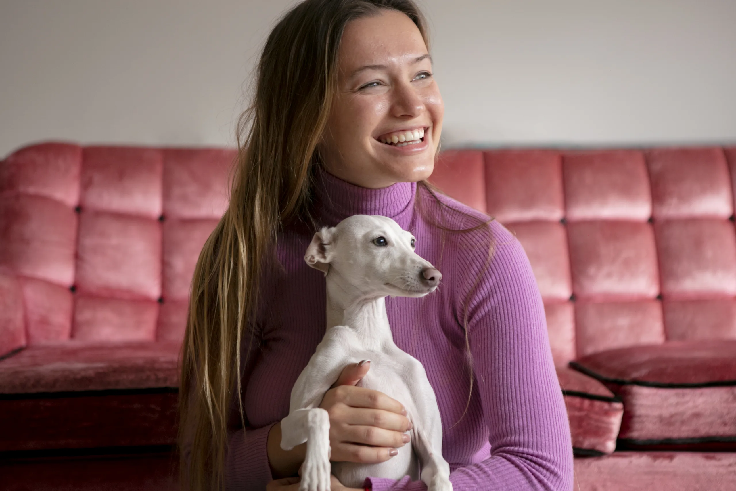 mulher sentada com cachorro no colo sorrindo