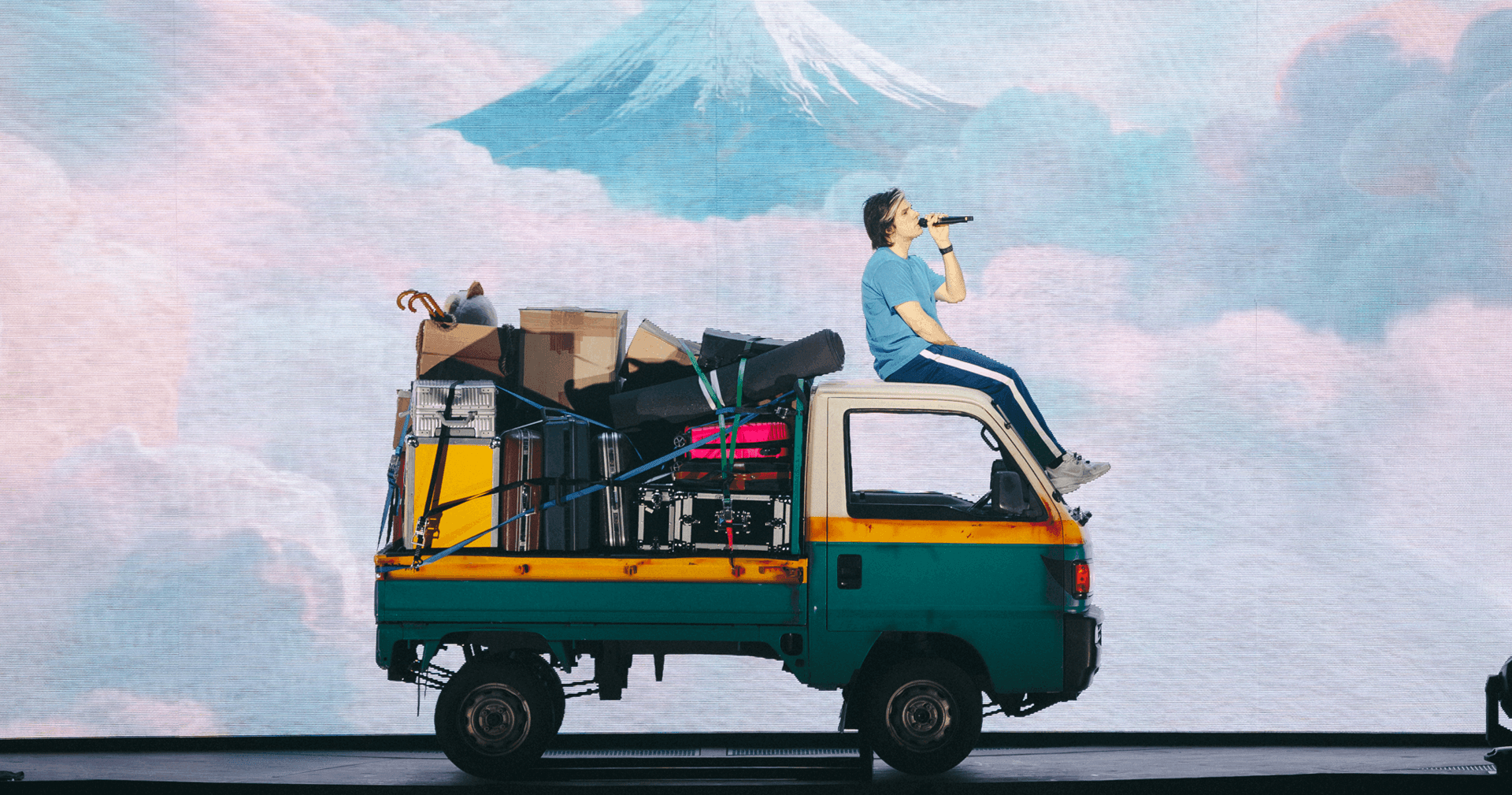 man standing in front of the back of the truck wearing a red coat