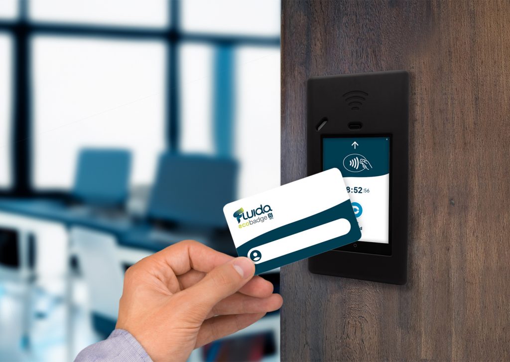 Dipendente che timbra l’ingresso al lavoro utilizzando un badge NFC davanti a una Fluida Station