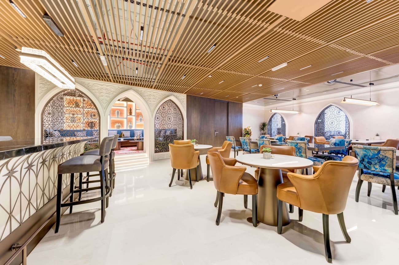 Elegant coworking café at TEC KSA with warm lighting, traditional accents, and stylish seating