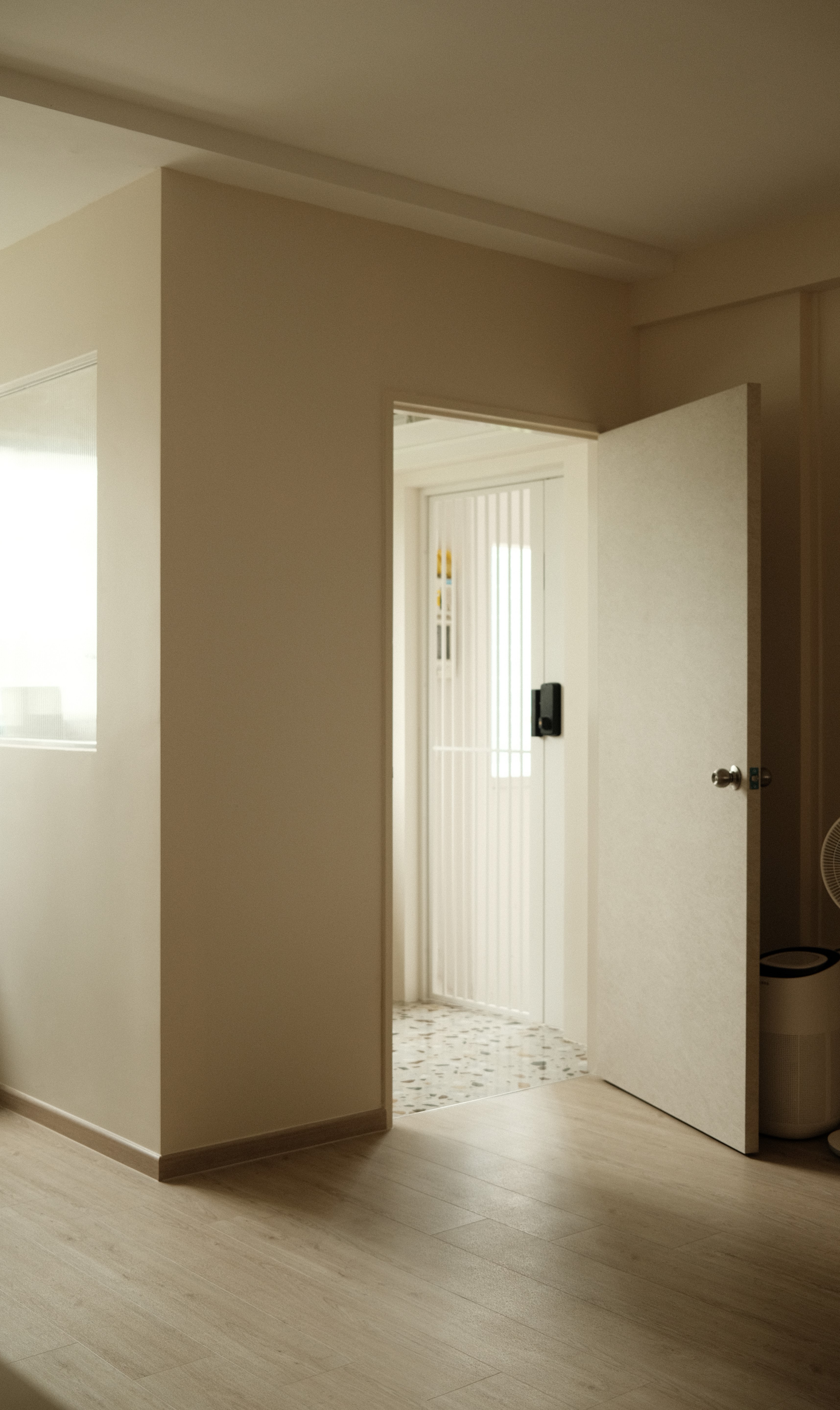 Entryway with open door, light wood flooring, and white gate, minimalist HDB design by Persqft