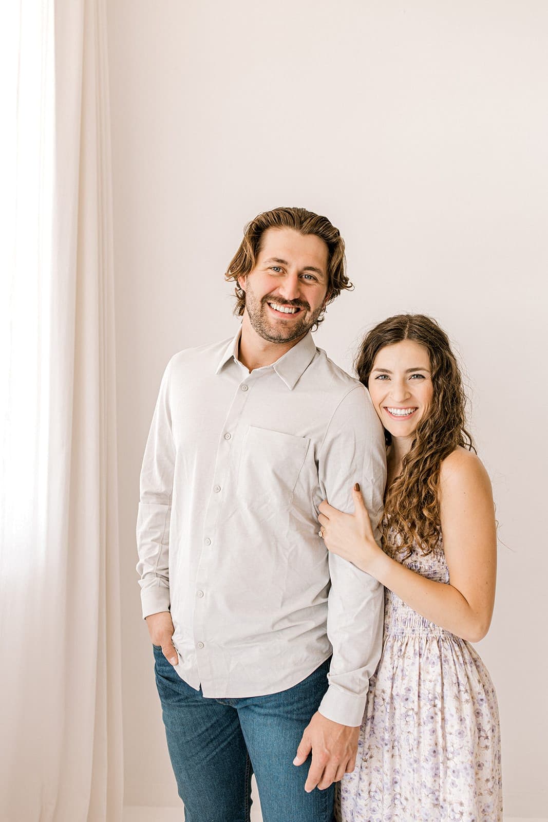 A couple standing together smiling at the camera inside Revelator Studio in Shreveport.