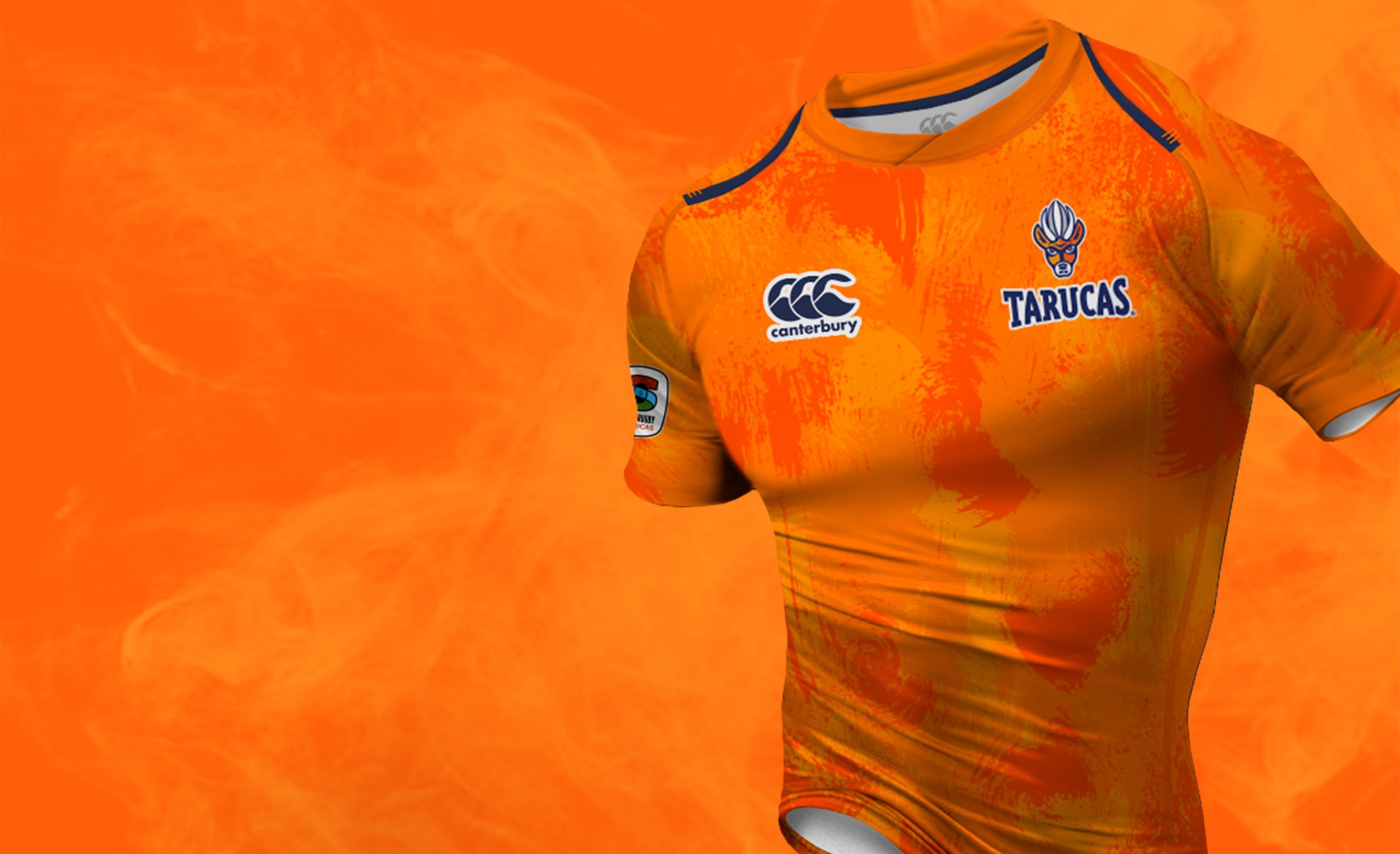 Orange rugby jersey with abstract patterns displayed against a matching orange background. Logos and the word "Tarucas" feature prominently. Energetic and bold.
