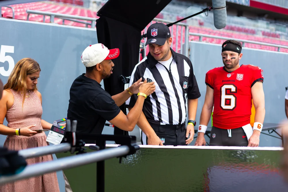 A close-up of a hand wearing multiple decorative rings against a blue background.