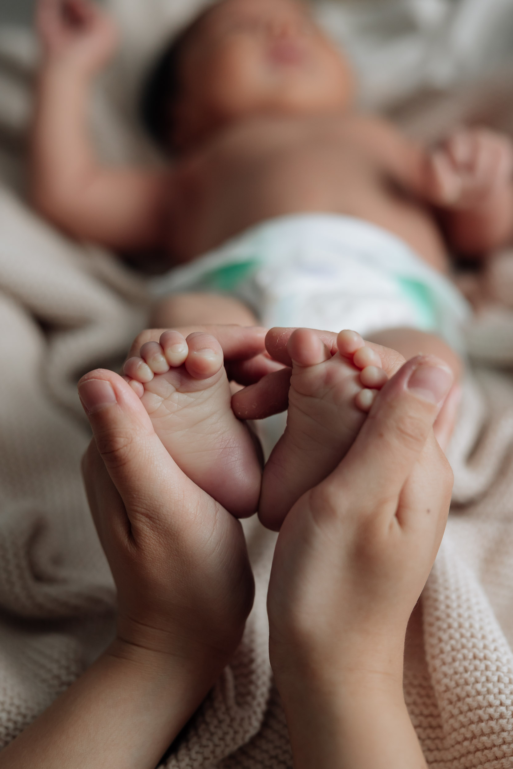 Close up of mother holding babys feet