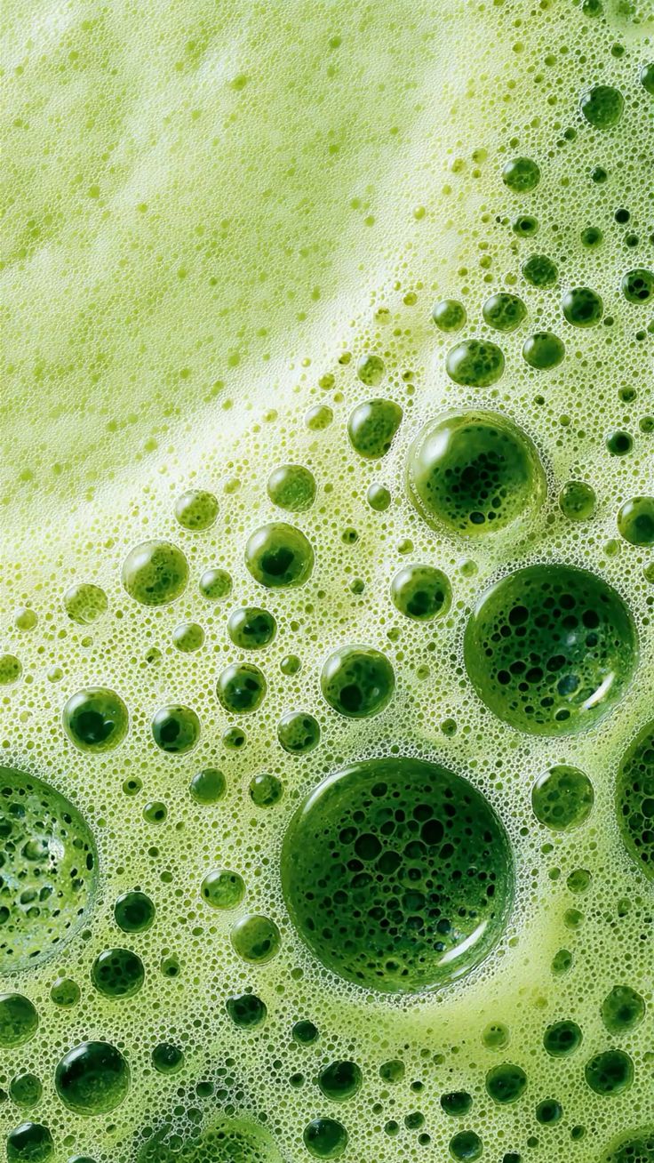 Close-up image of a green OkiOne drink with frothy bubbles