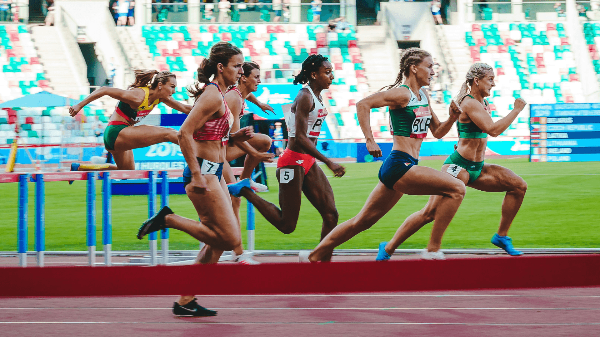 Athletes competing in a hurdles race, symbolising how precision, performance optimisation, and real-time insights in sports mirror AI applications in the energy sector