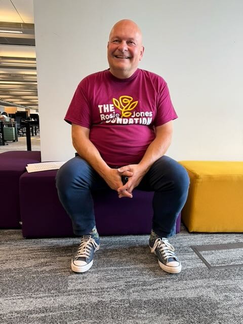 An image of Rosie Jone's Dad sitting smiling wearing a RJ foundation T shirt