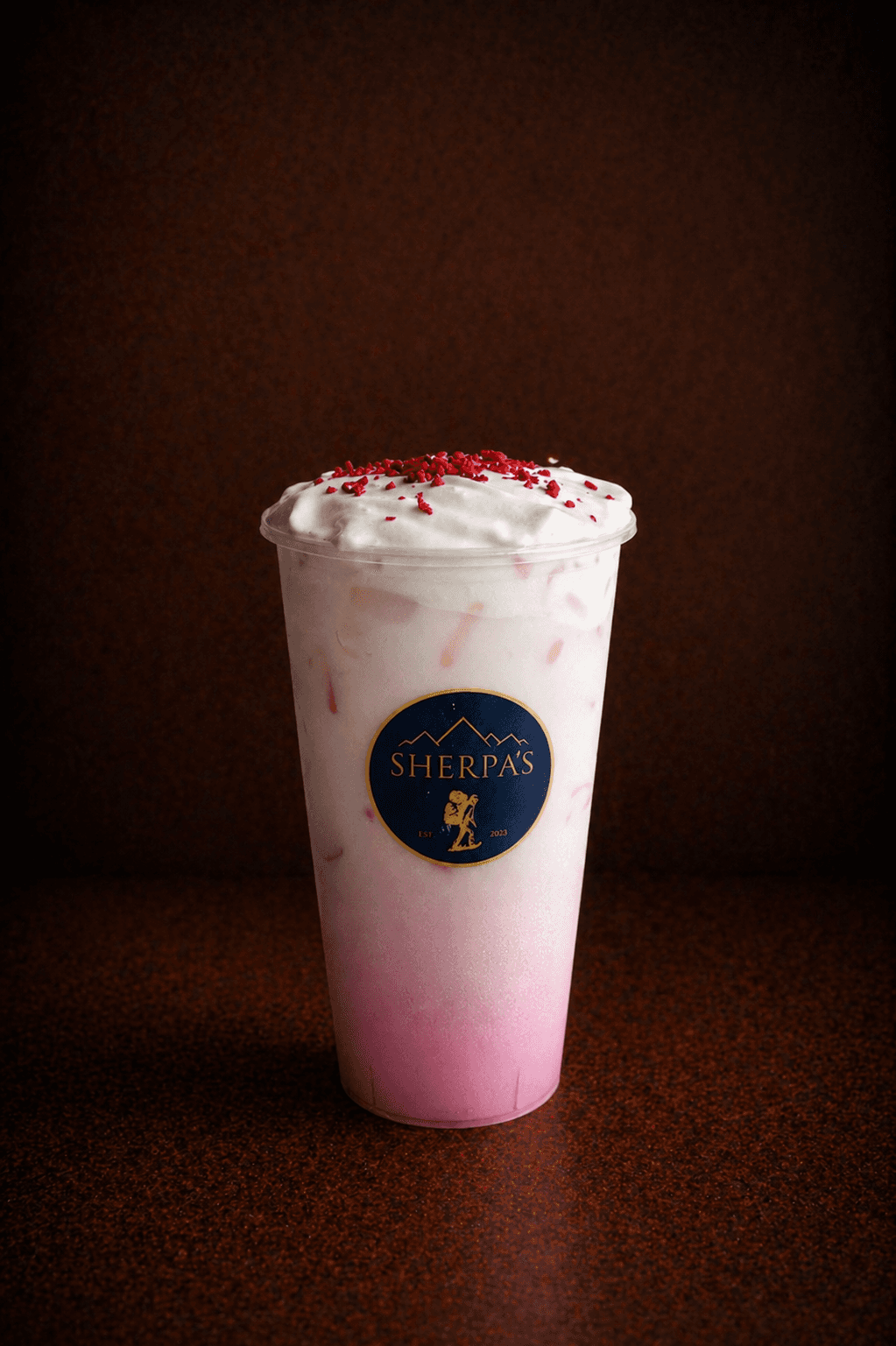 Sakura Strawberry Cloud drink in a Café Sherpa's cup, Brookfield WI. Strawberry-infused milk with cherry blossom, topped with vanilla sweet cream and dried strawberries.