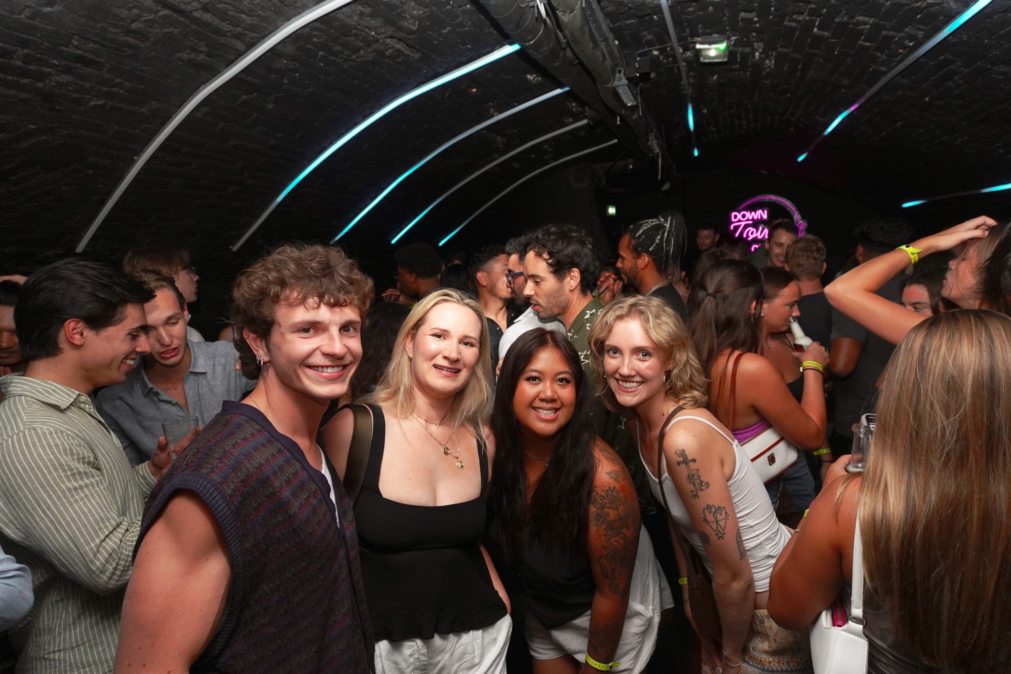 A group of travelers gathering at the start of the night in Nice, smiling and chatting inside a bar before heading into the Old Town.