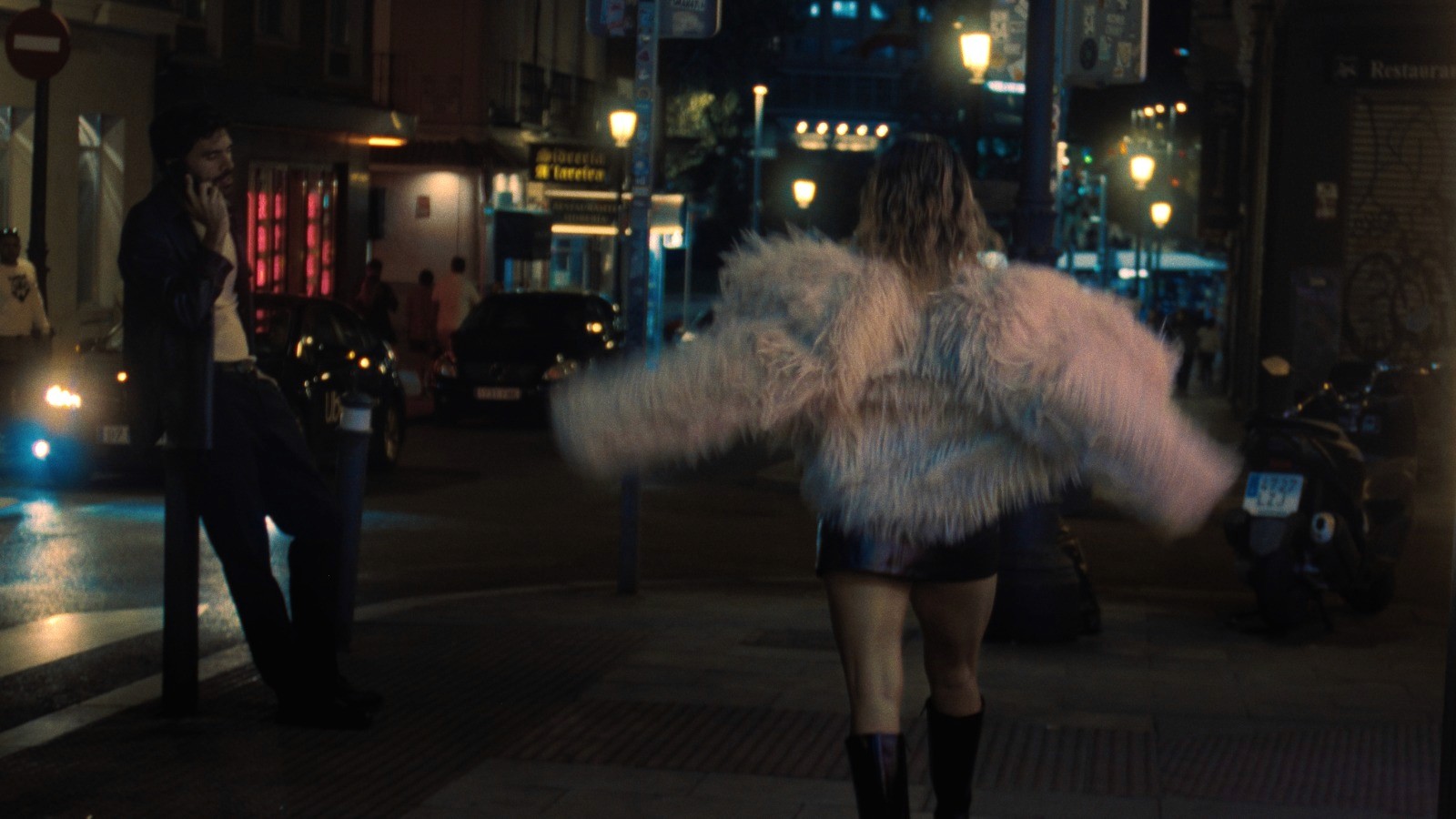 Close-up of a yellow tennis ball sitting on a green court, positioned near the white center line.
