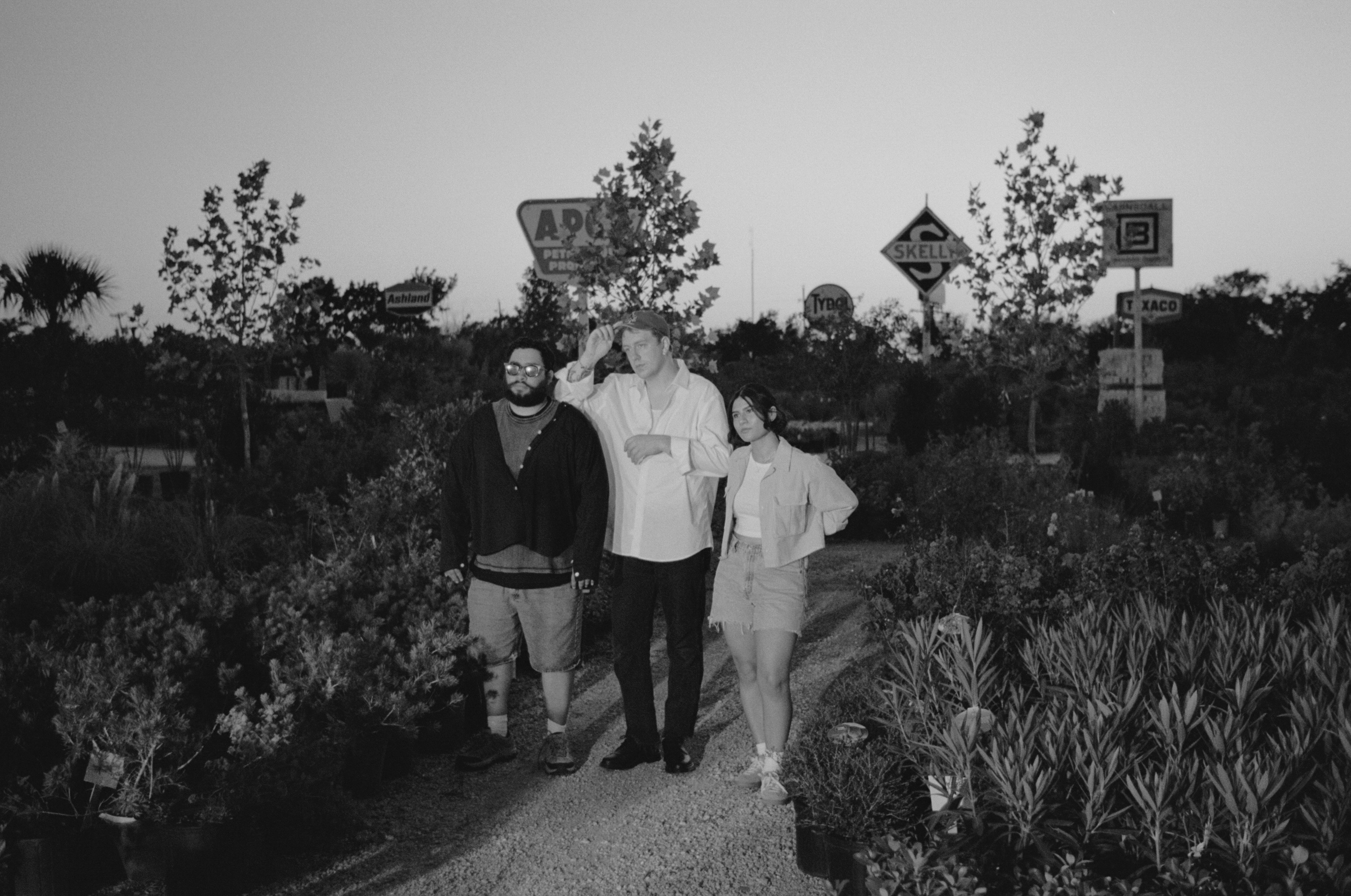 A performer sits at a piano under a single spotlight in a darkened space, creating an intimate atmosphere.