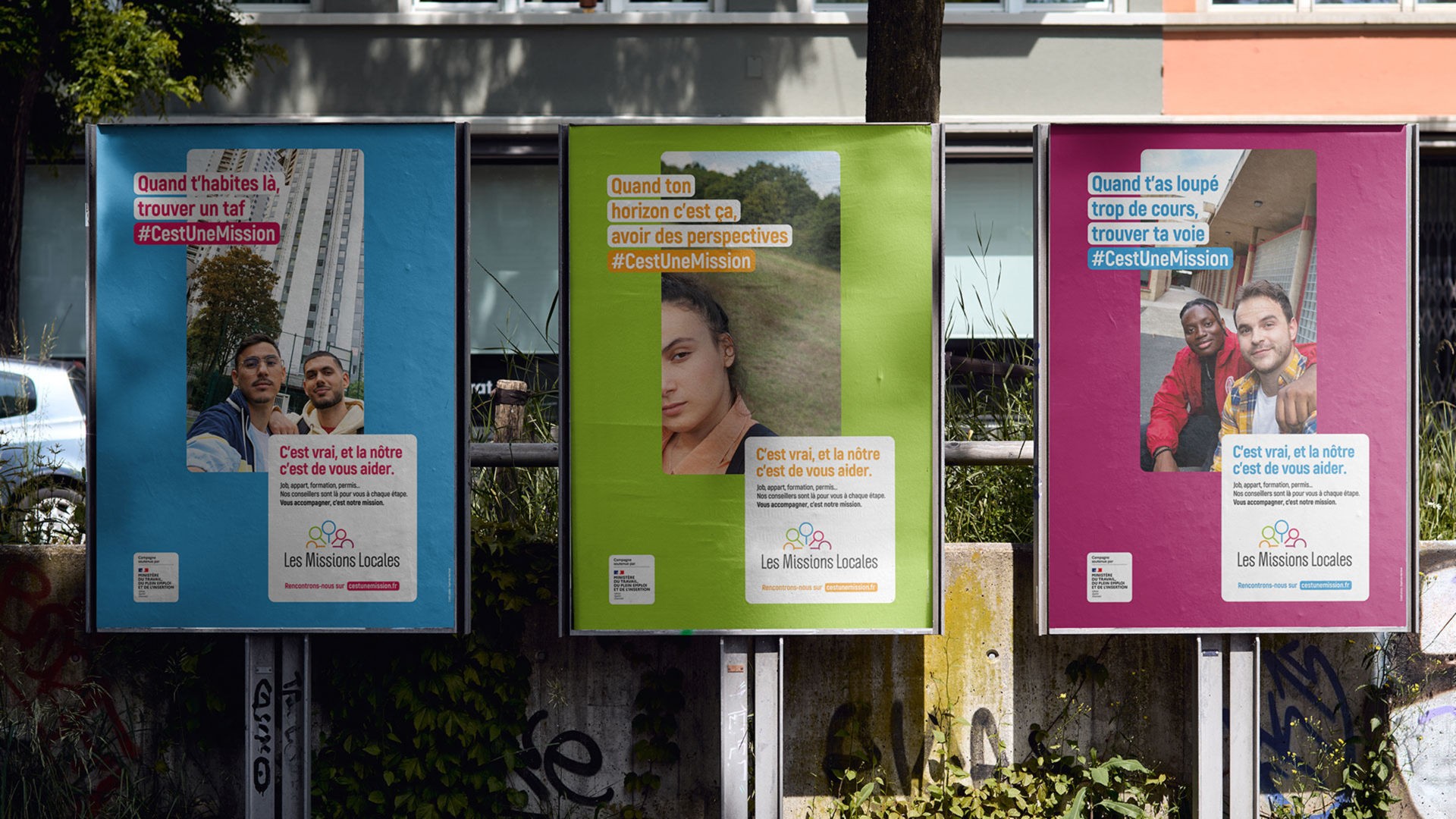 Trois affiches publicitaires colorées (bleu, vert, magenta) pour "Les Missions Locales" affichées côte à côte sur un mur. Chaque affiche montre des jeunes et un slogan avec le hashtag #CestUneMission.
