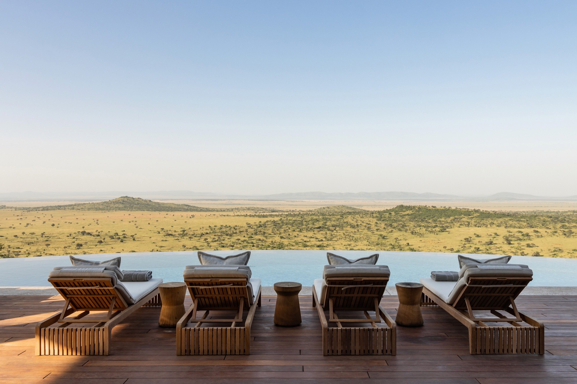 Loungers lined along an infinity pool above the Serengeti